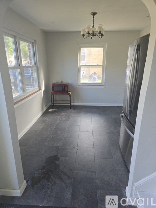 A room with a black floor and a chandelier hanging from the ceiling.