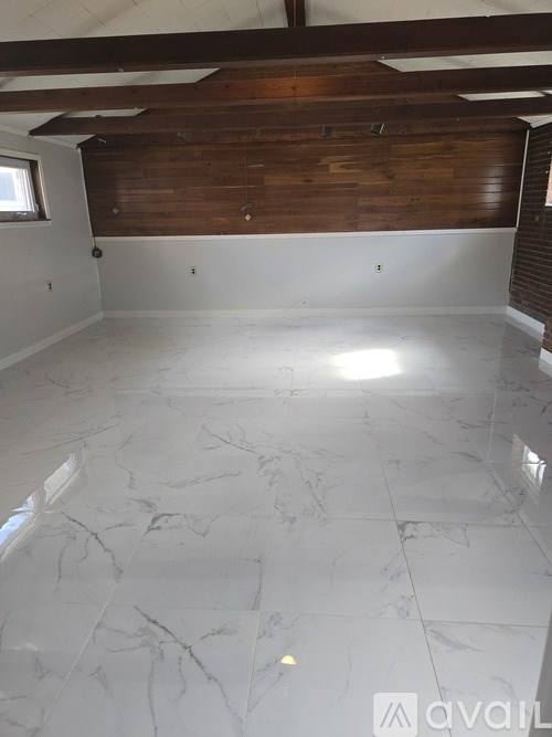 A room with a wooden ceiling and a marble floor.