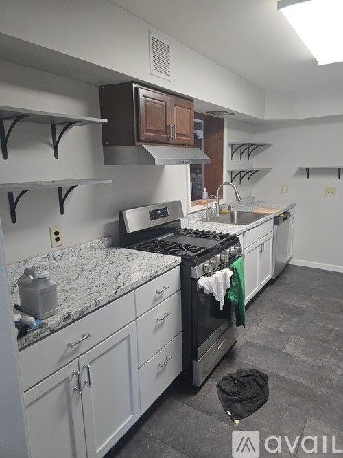 A kitchen with a black stove top oven and white cabinets.