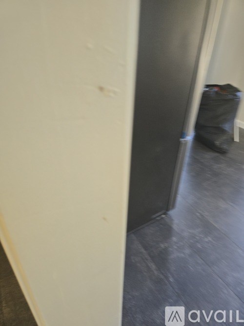 A room with a white wall and a grey floor.