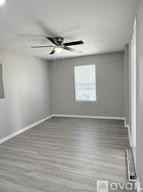 A room with a ceiling fan and a window.