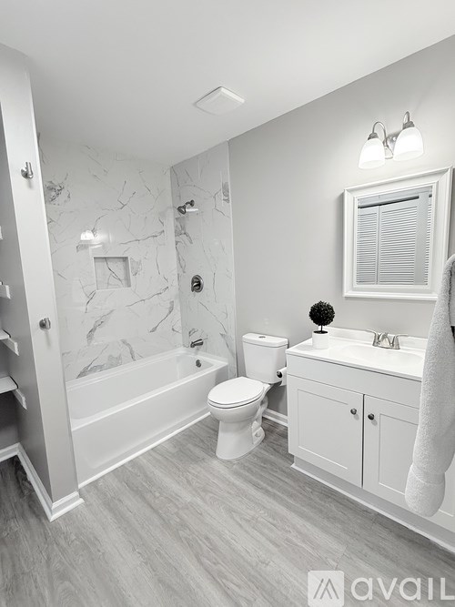 A bathroom with a marble patterned shower and a toilet.