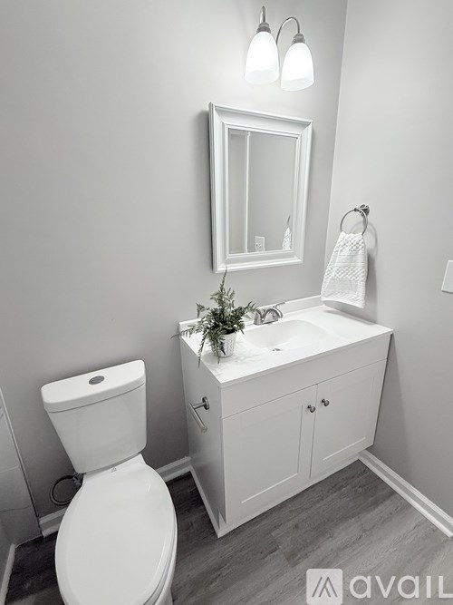 A white toilet sits next to a white sink in a bathroom.