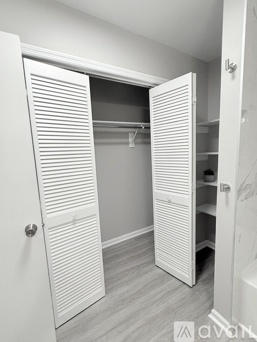 A white closet with a sliding door is open.