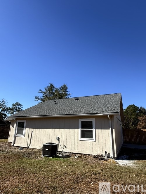 A small house with a black trash can in front of it.