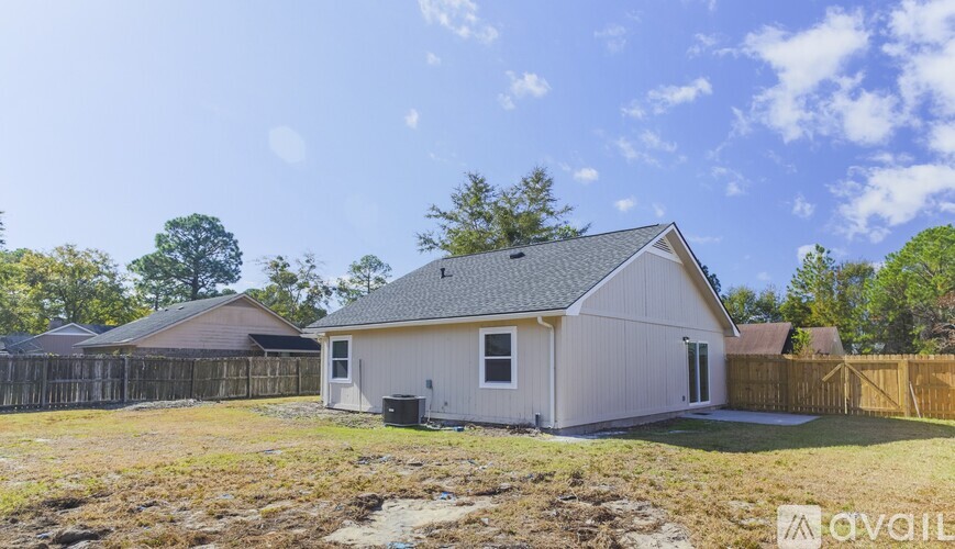 A house with a fence and trees in the background.