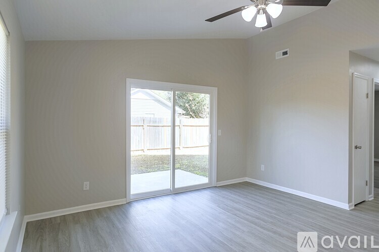 A spacious room with a ceiling fan and grey flooring.
