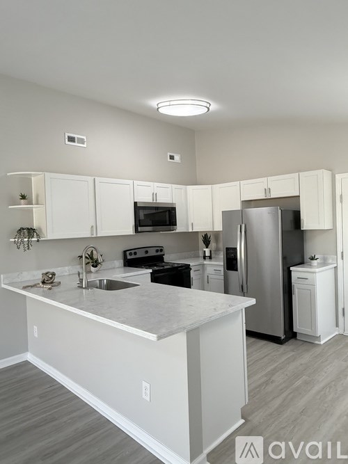 A kitchen with white cabinets and a marble countertop.