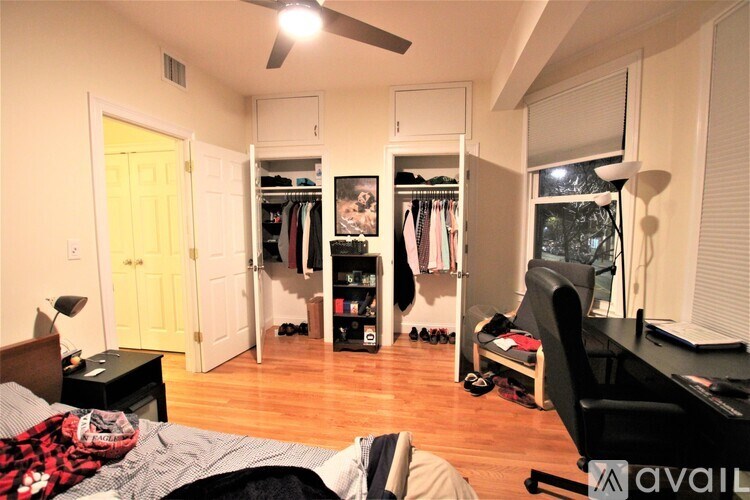 A bedroom with a bed, desk, and closet.