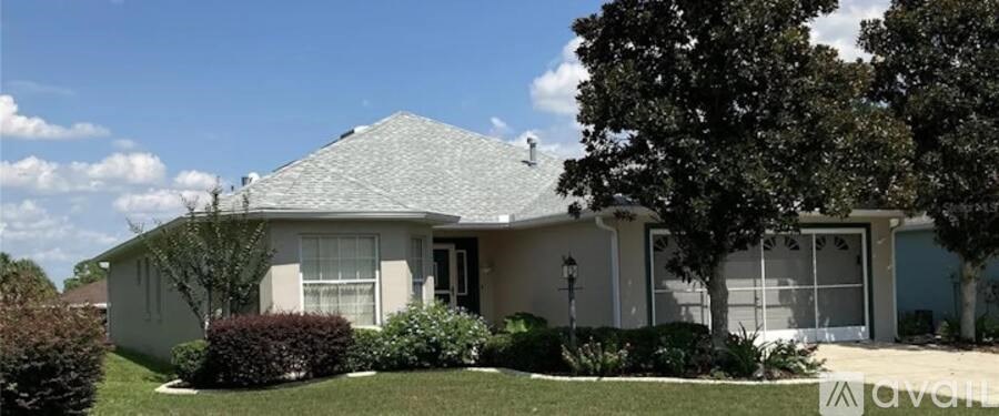A house with a grey roof and a tree in front.