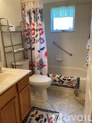 A bathroom with a toilet, sink, and shower curtain.