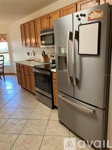A kitchen with a refrigerator, oven, and microwave.