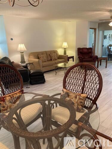 A living room with a sofa, chairs, and a lamp.