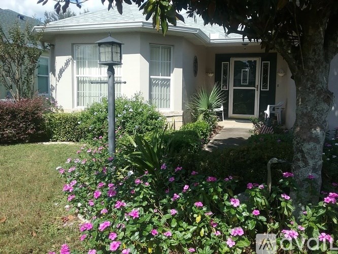 A house with a green door and a white fence.
