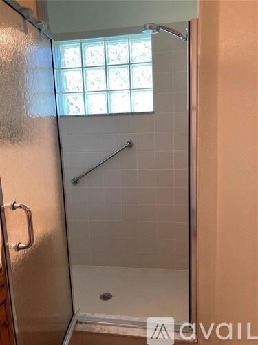 A shower area with a glass door and a window.