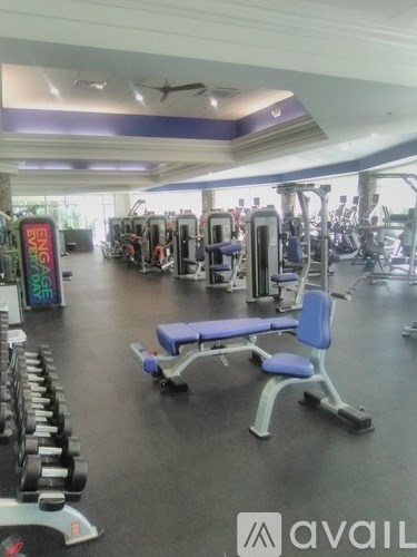 A gym with a variety of equipment including weights and machines.