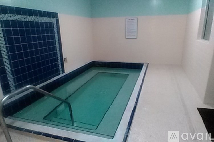 A small indoor swimming pool with a metal ladder.