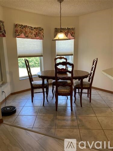 A dining room with a table and chairs.