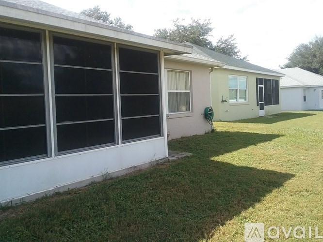 A white house with a green hose on the wall.