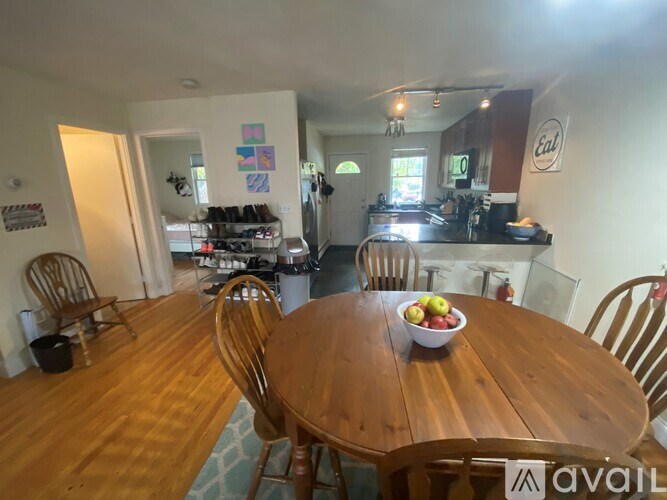 A dining room with a wooden table and chairs.