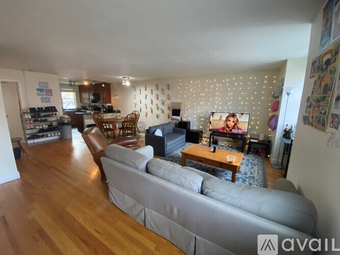 A living room with a grey sofa and wooden floors.