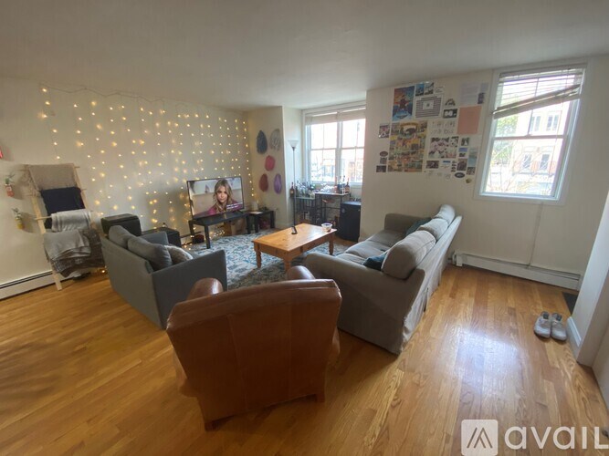 A living room with a brown leather chair and a grey couch.