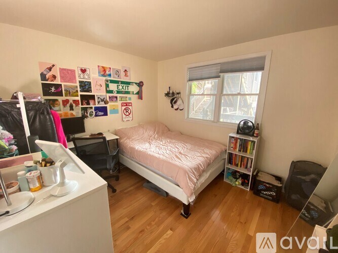 A bedroom with a bed, desk, and a window with blinds.