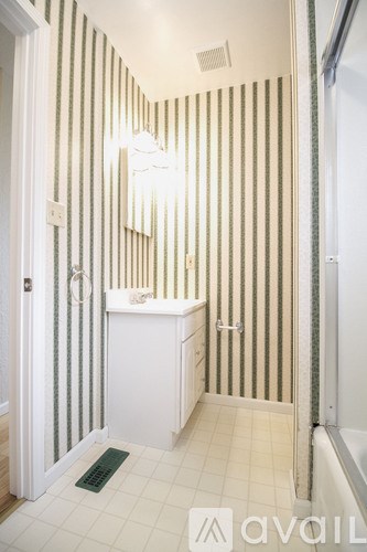 A bathroom with a white sink and striped wallpaper.