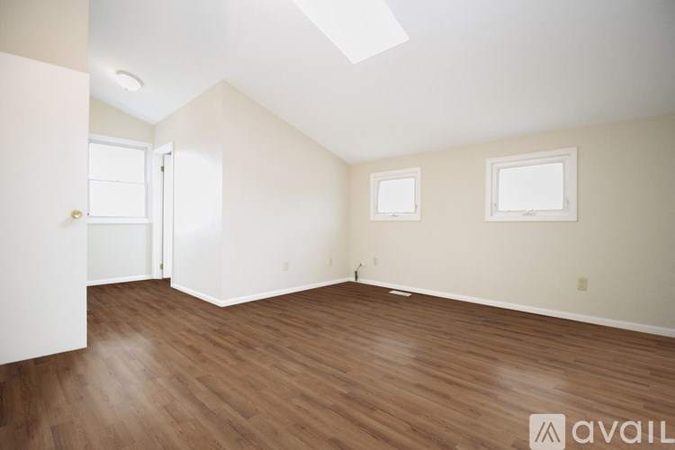 A room with wooden flooring and a skylight.