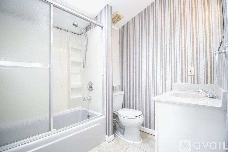 A bathroom with a toilet, sink, and bathtub.