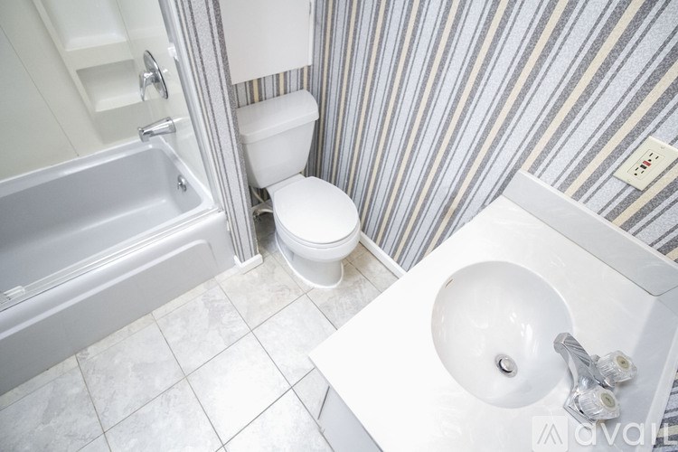 A white toilet sits in a bathroom next to a sink.