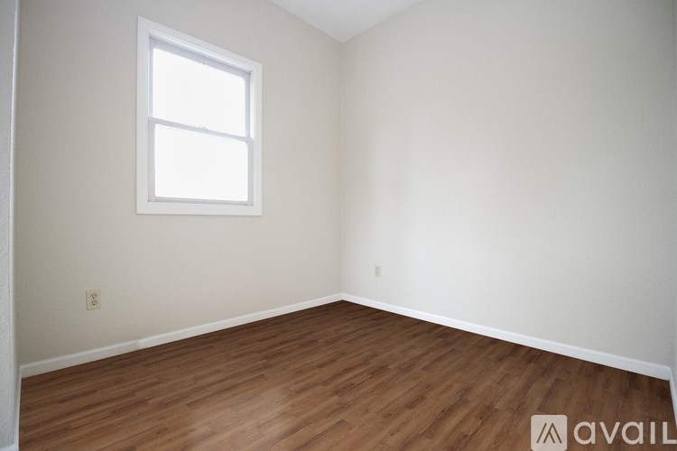A room with wooden flooring and a window.