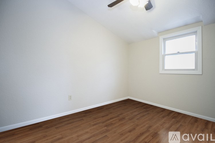 A room with a window and wooden flooring.