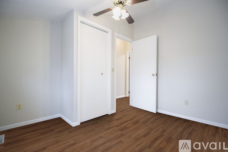 A room with two doors and a ceiling fan.