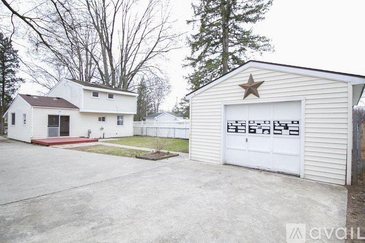 A white house with a garage and a red ramp in front.