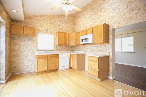 A kitchen with wooden cabinets and a white dishwasher.