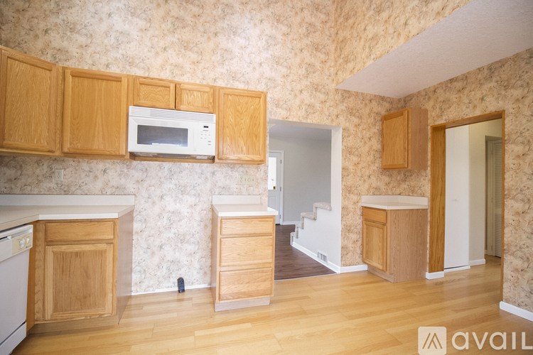 A kitchen with wooden cabinets and a white microwave.