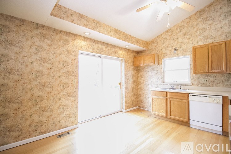 A kitchen with wooden cabinets and a white dishwasher.