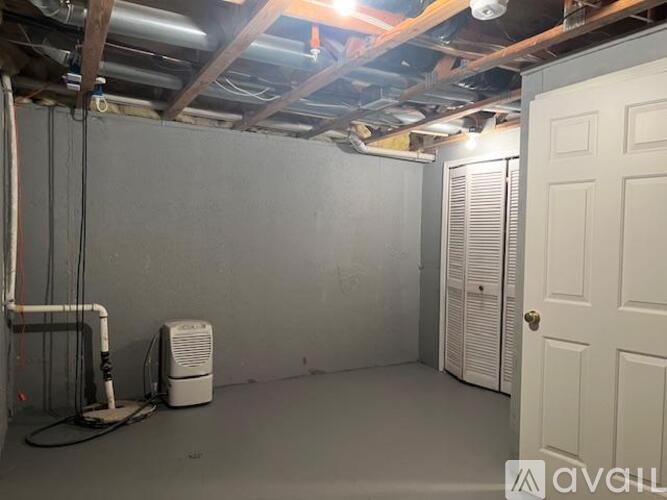 A room with a white door, a window with blinds, and a wall-mounted air conditioner unit.