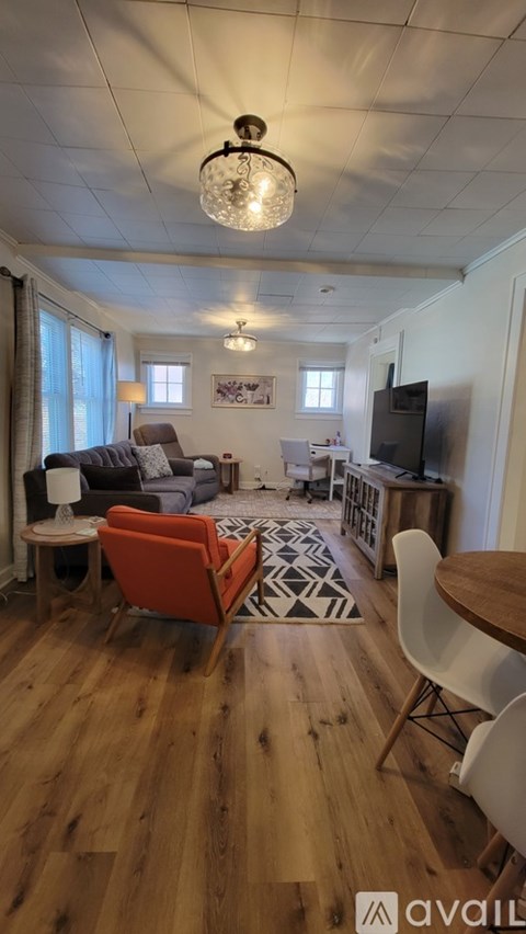 A living room with a grey couch and a wooden floor.