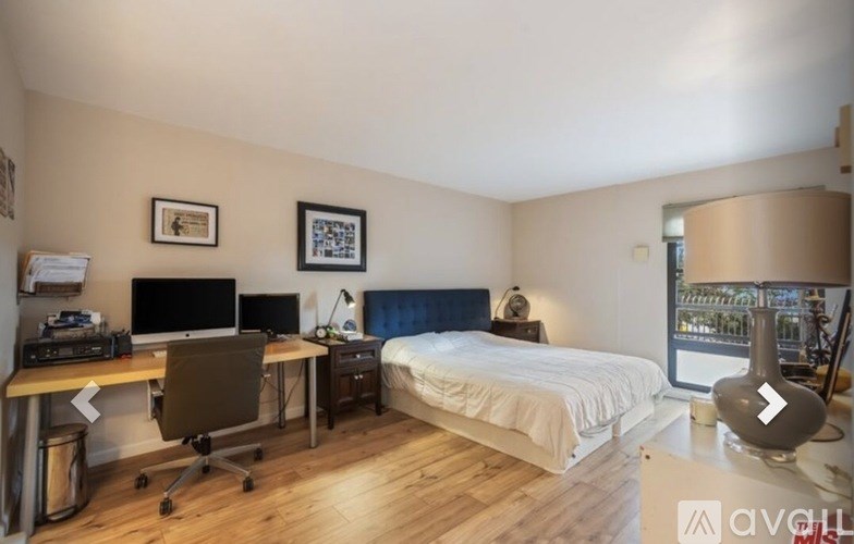 A bedroom with a bed, desk, and chair.