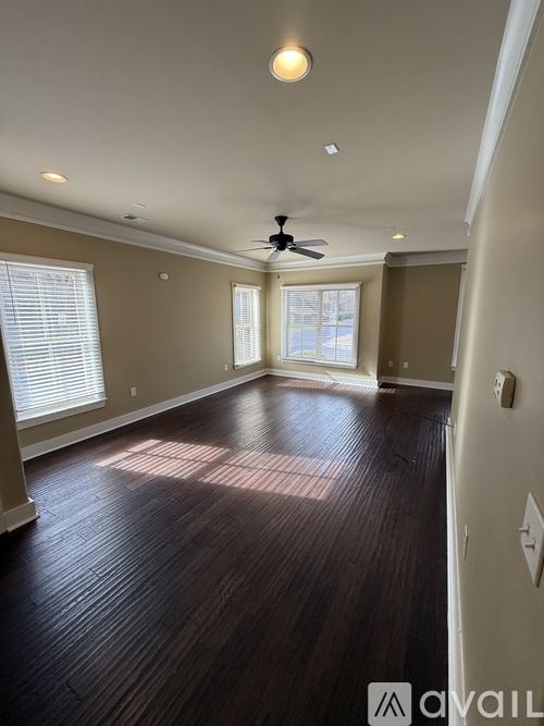 A room with a ceiling fan and a window with blinds.