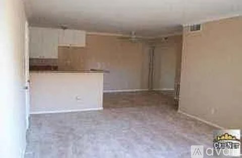 A room with a white wall and a brown floor.