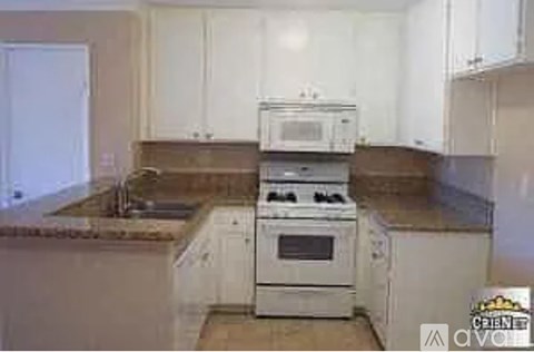 A white stove and oven in a kitchen with white cabinets.