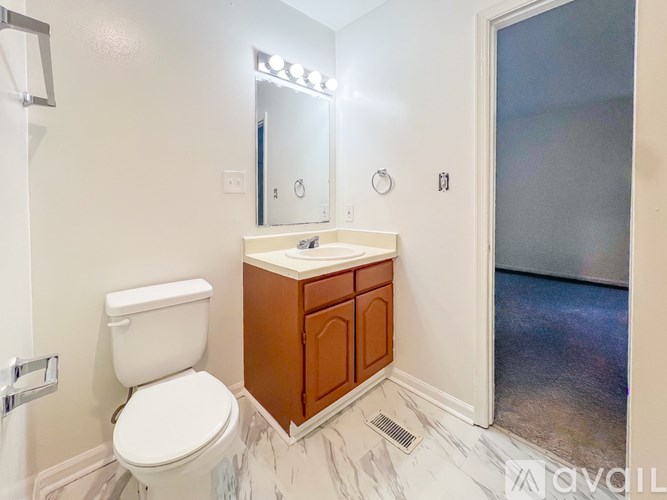 A white toilet sits next to a sink in a bathroom.
