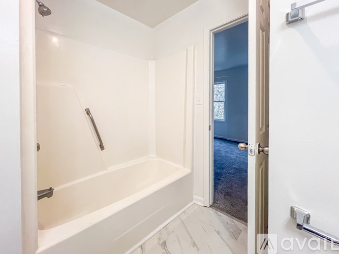 A white bathroom with a walk-in shower and a door leading to a balcony.