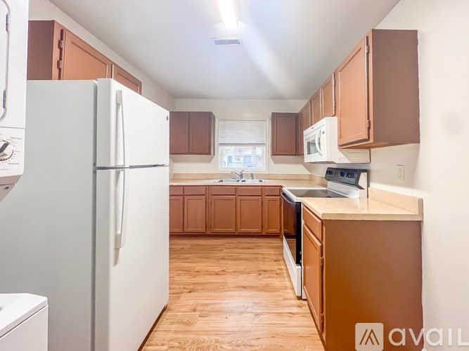 A kitchen with wooden cabinets and a white refrigerator.