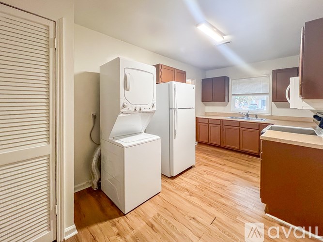 A kitchen with wooden floors and white appliances.