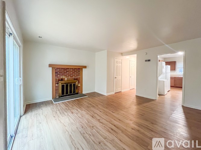 A room with a fireplace and wooden flooring is available for rent.