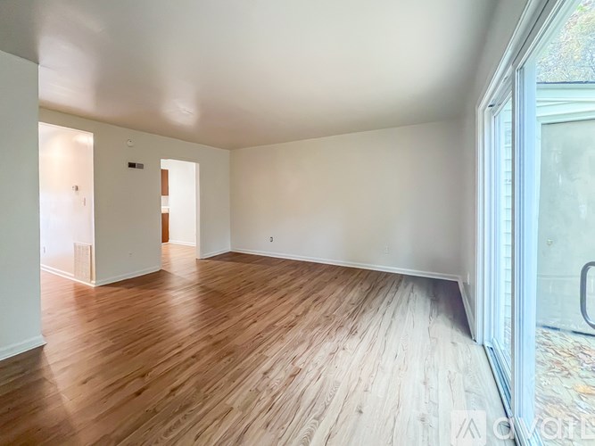 A room with wooden flooring and white walls.